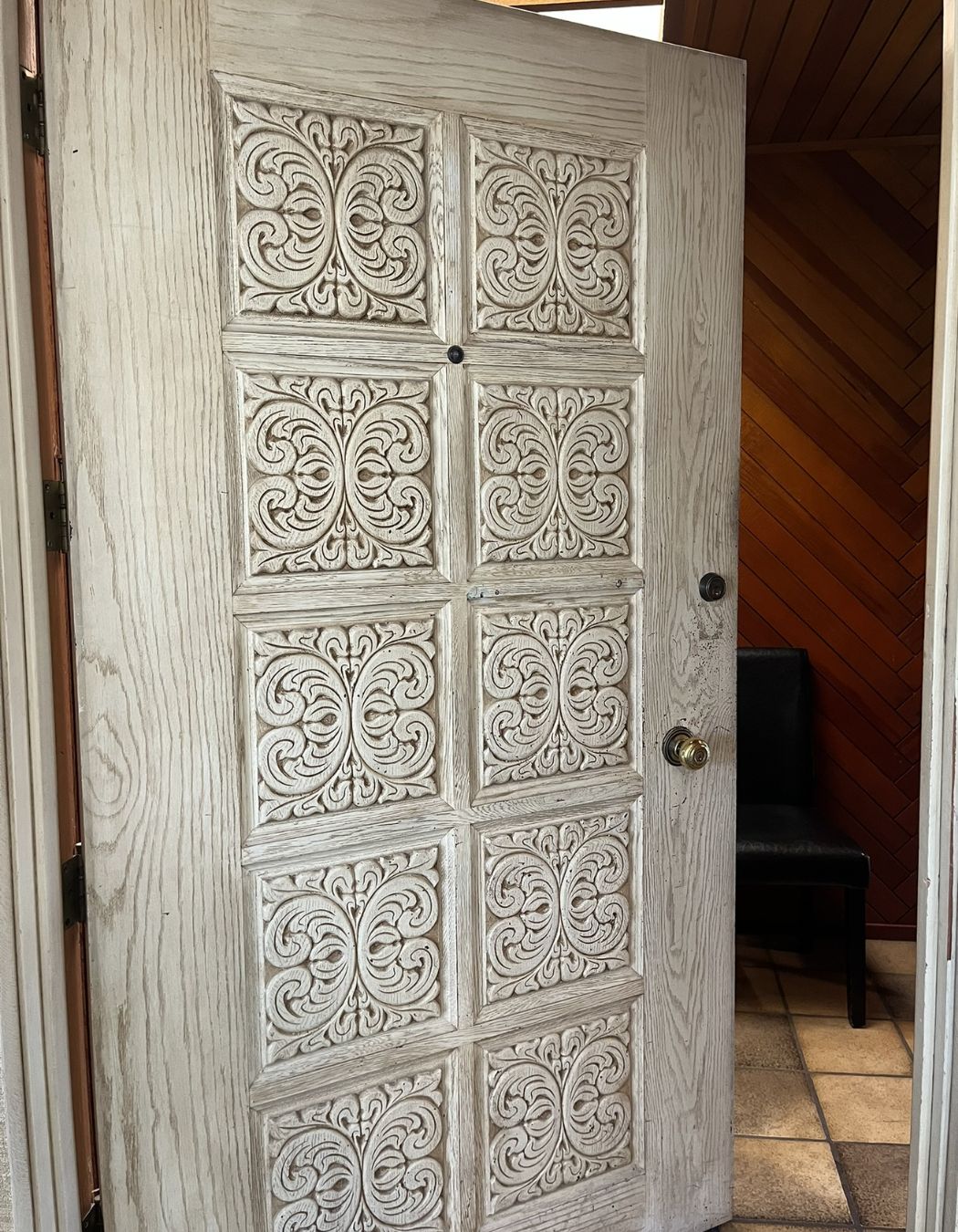 Simple white door at the entrance to a quiet interior space.
