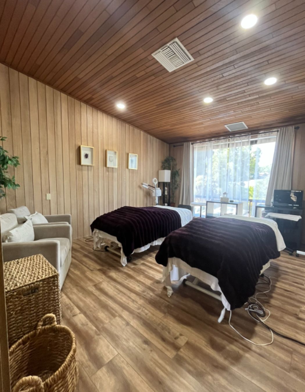 Couples massage room captured from another angle, highlighting soft lighting and twin tables.