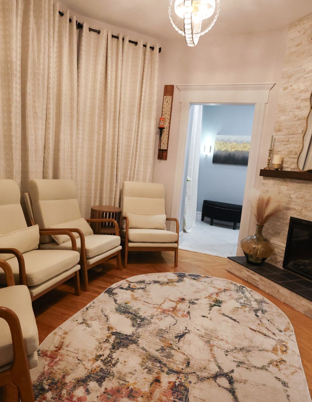 Seating area in Fireplace Relaxation Lounge at Elysian Spa at In Vogue in Oswego, New York, with warm wood floors and cozy fireplace.