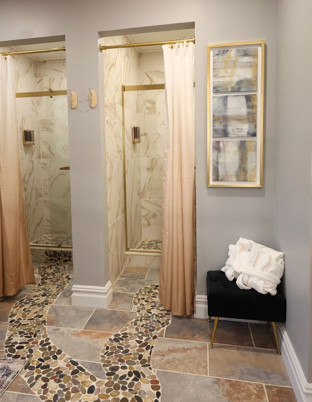 Private shower room at Elysian Spa at In Vogue in Oswego, New York, featuring two individual showers and a clean tile floor.